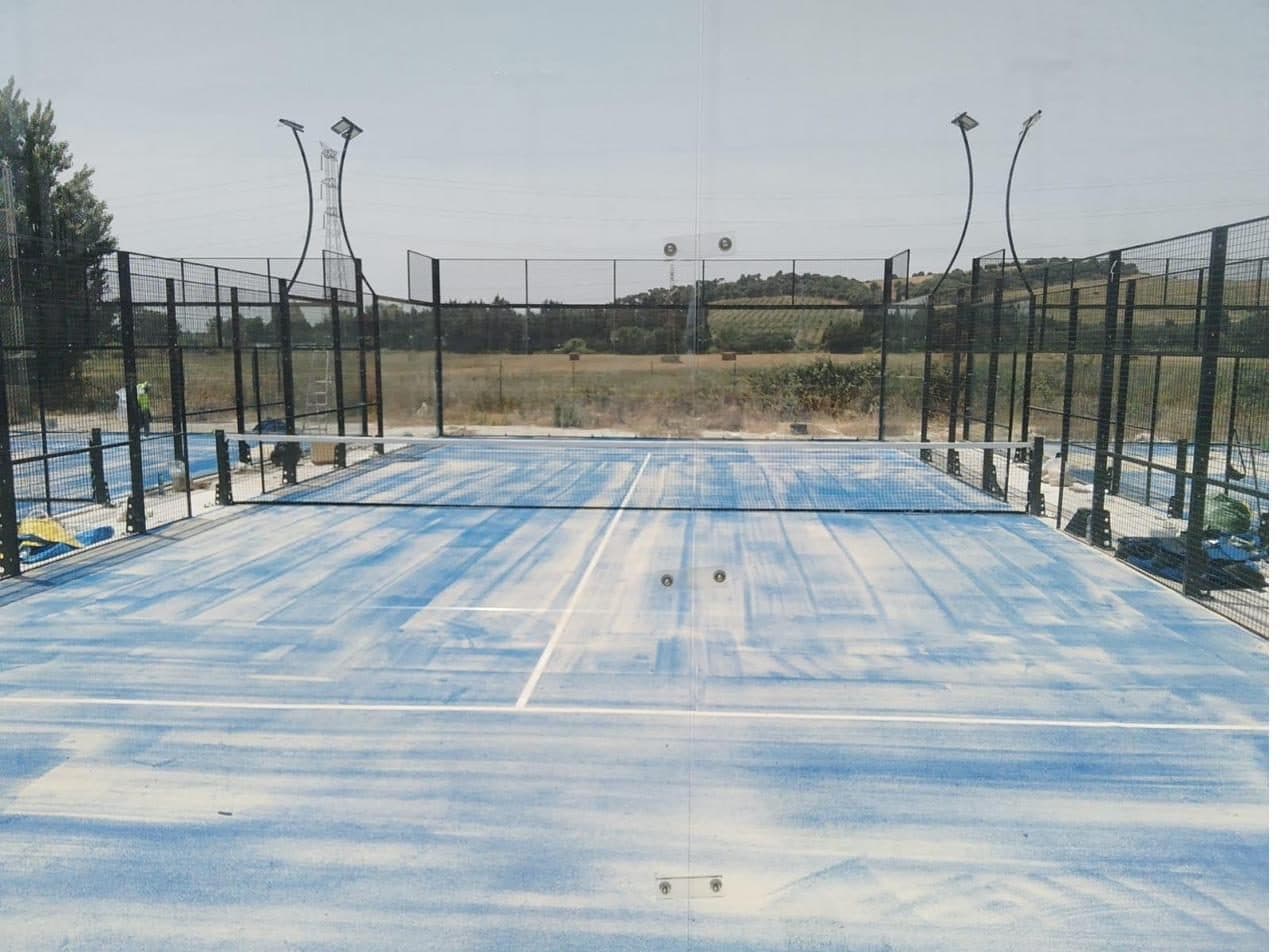 Pista de pádel en un resort mediterráneo junto a la piscina