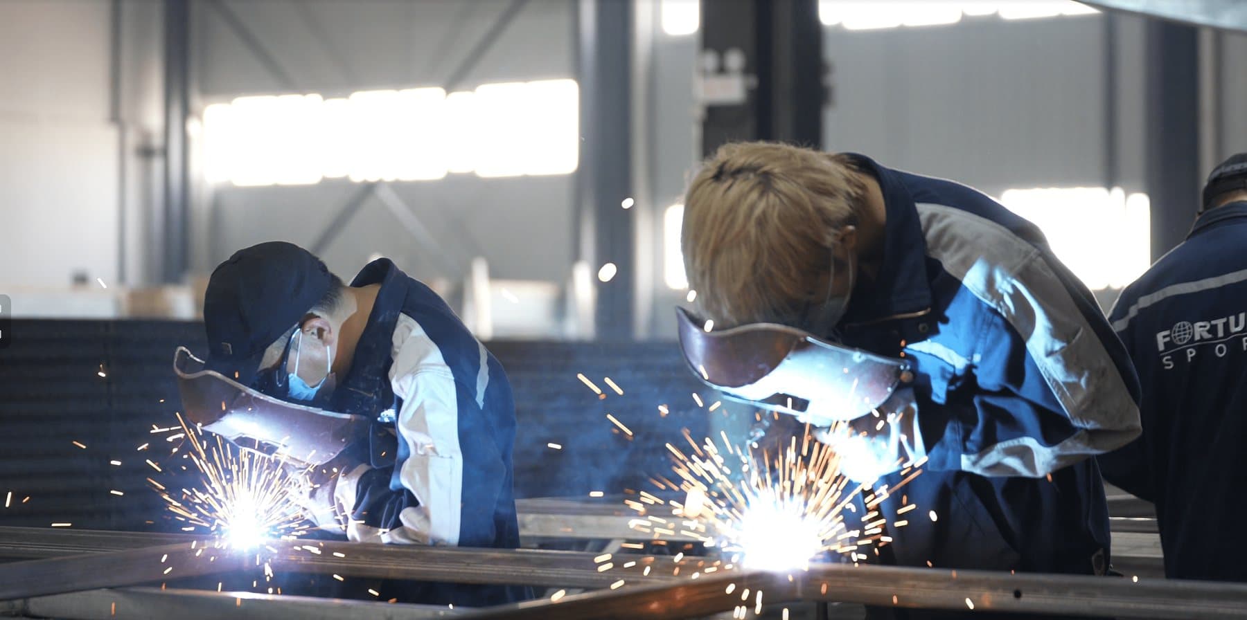 Soldadores montando la estructura de acero de una pista de pádel en la fábrica de Fortune