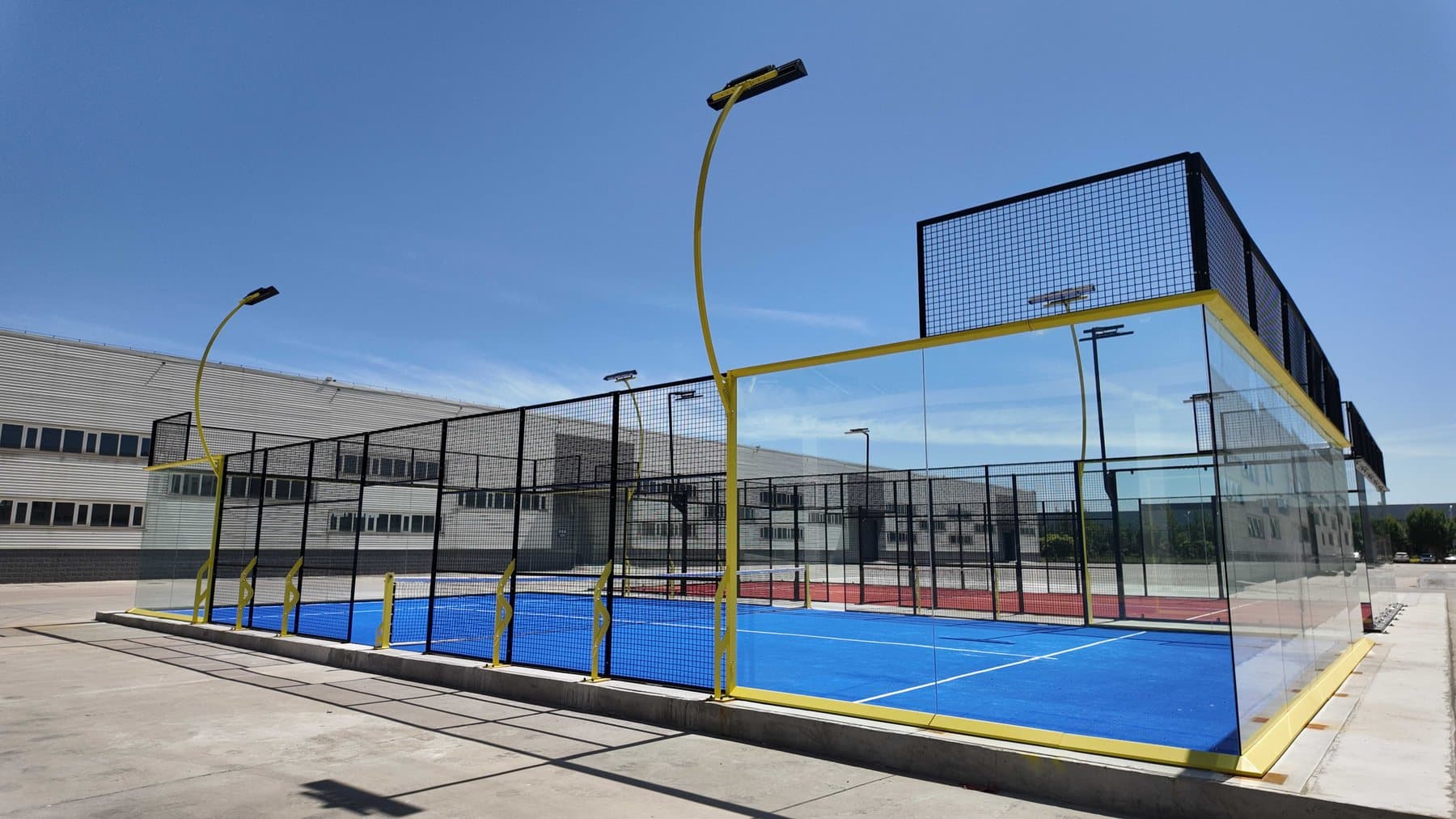 Pista de pádel Fortune con estructura amarilla montada junto a la nave de fabricación