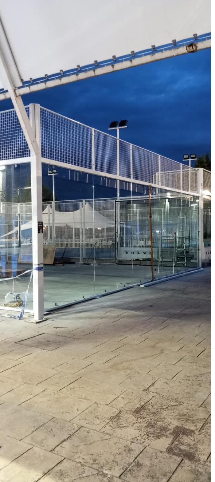 Detalle del poste de acero galvanizado y panel de vidrio templado de una pista de pádel